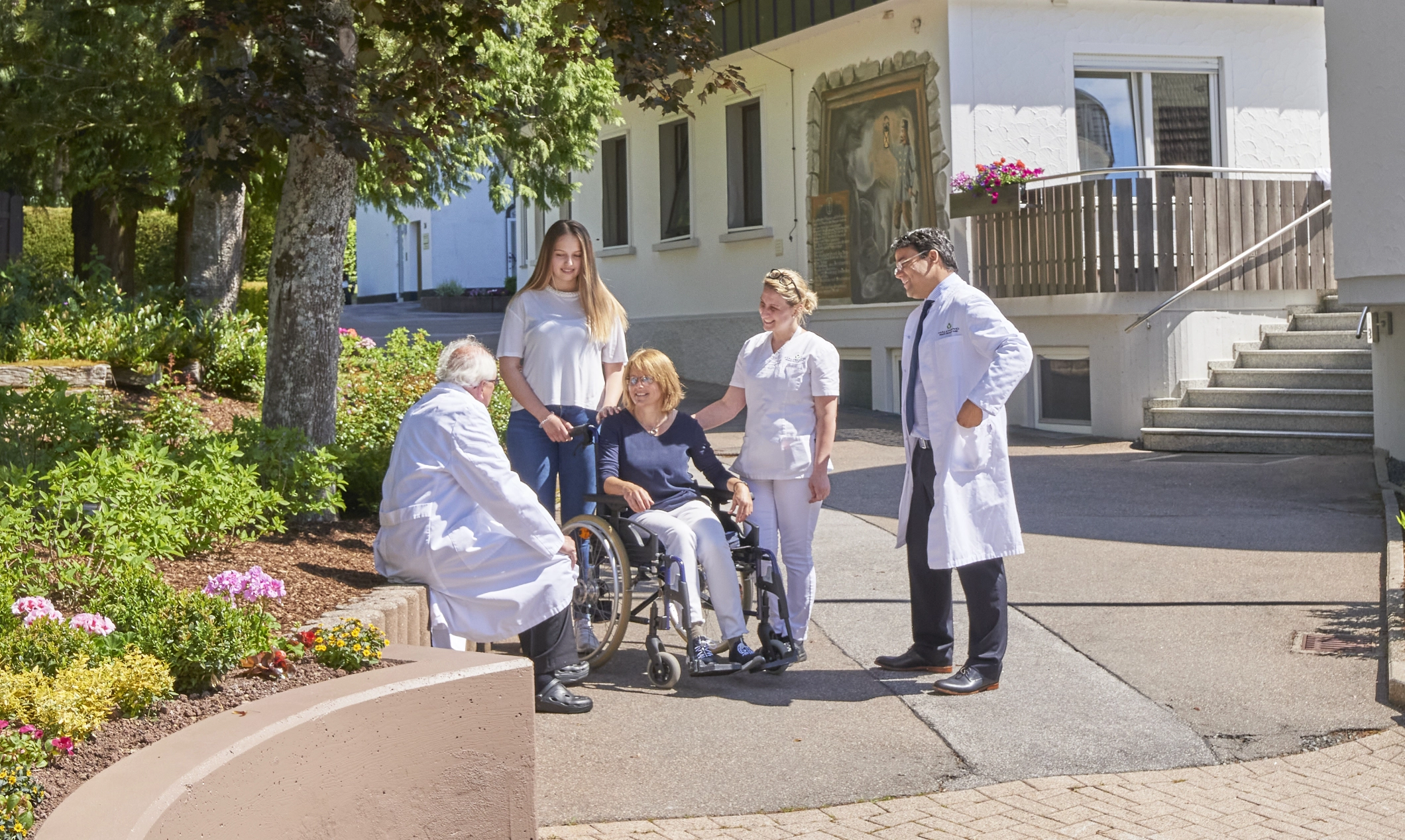 Dr. Nolting und Kollegen im Gespräch mit einer Patientin vor der Klinik