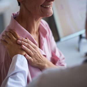 Middle Aged Woman Receiving Support from Doctor during Cancer Consultation