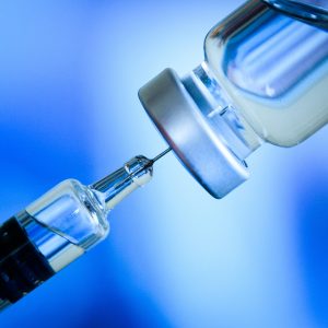 Close up of flu and measles vaccine vials for baby caccination, medicine and drug concept