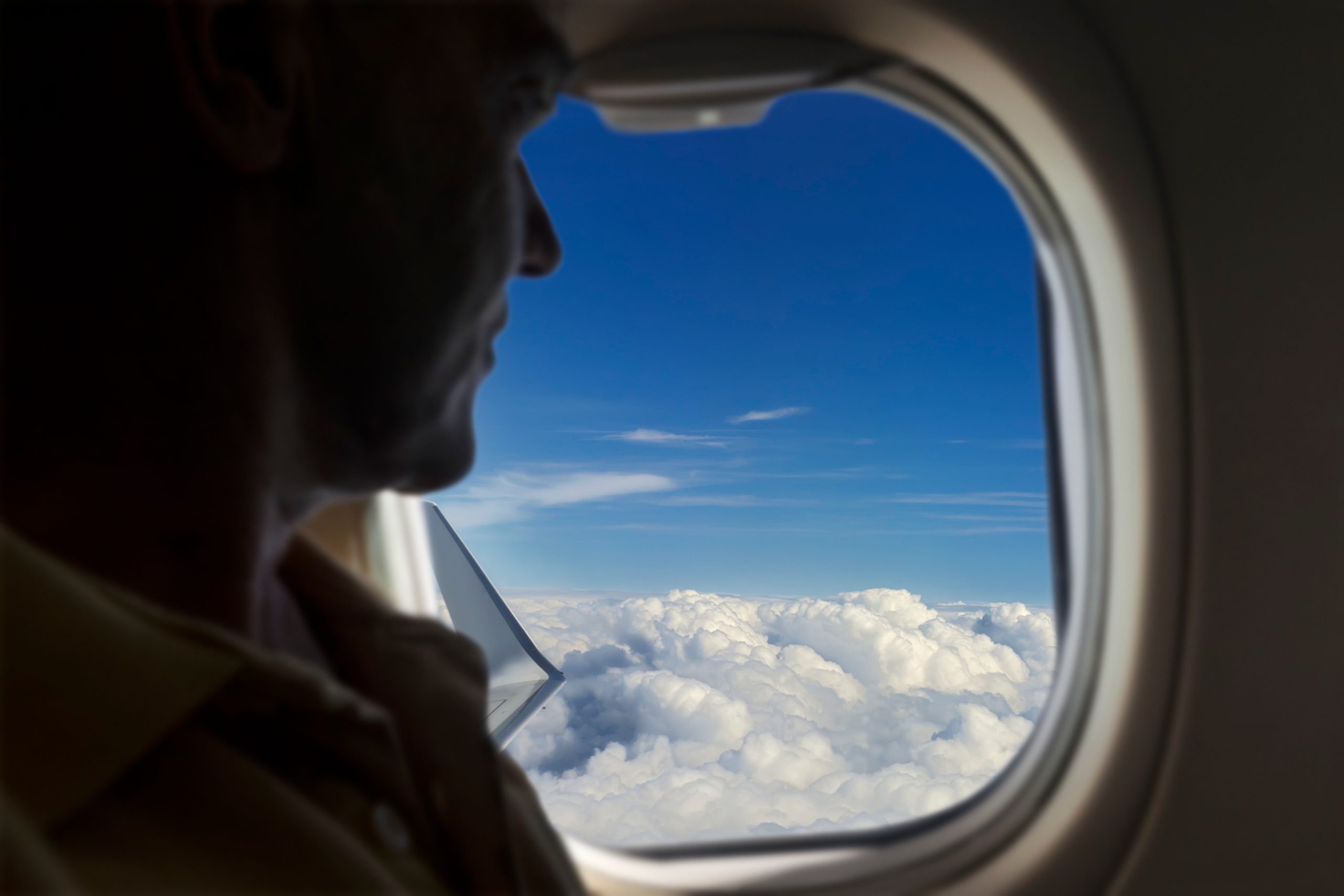 commercial plane passenger sitting and looking out the window